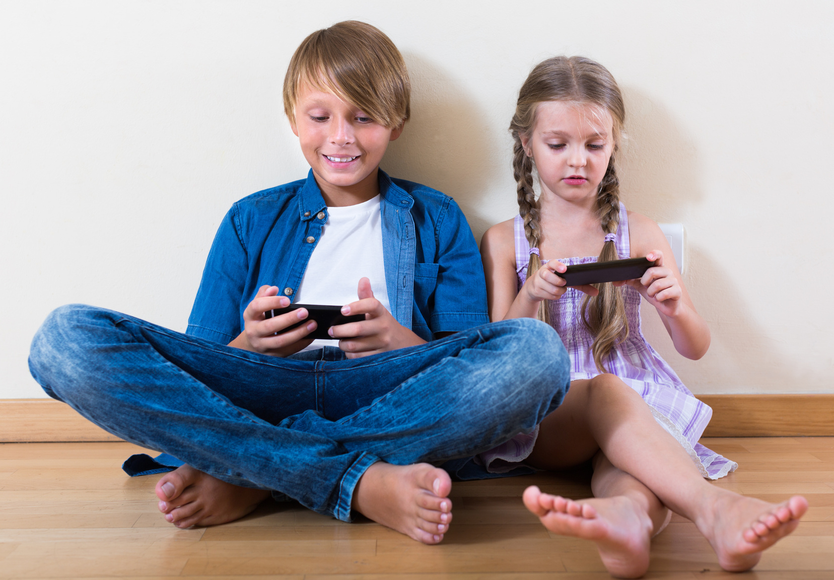 children looking at screen of smartphones
